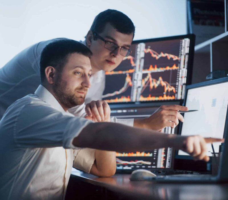 Team Stockbrokers Are Having Conversation Dark Office With Display Screens Analyzing Data Graphs Reports Investment Purposes Creative Teamwork Traders Min